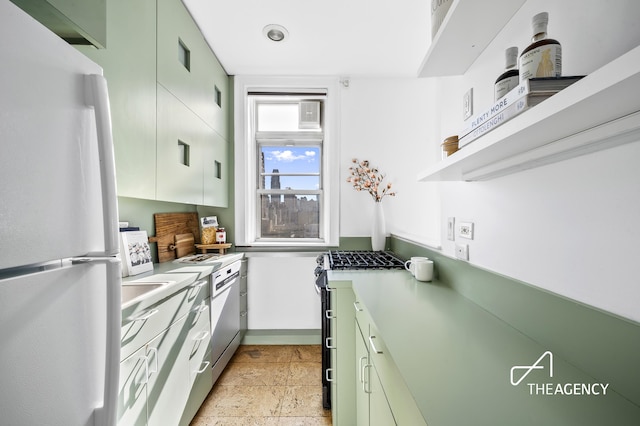 kitchen with freestanding refrigerator, stainless steel gas stove, and light countertops