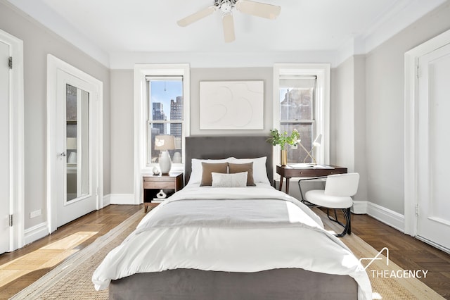 bedroom featuring multiple windows, baseboards, a ceiling fan, and access to outside