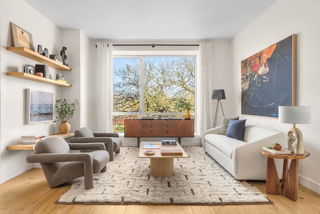 sitting room with baseboards and wood finished floors