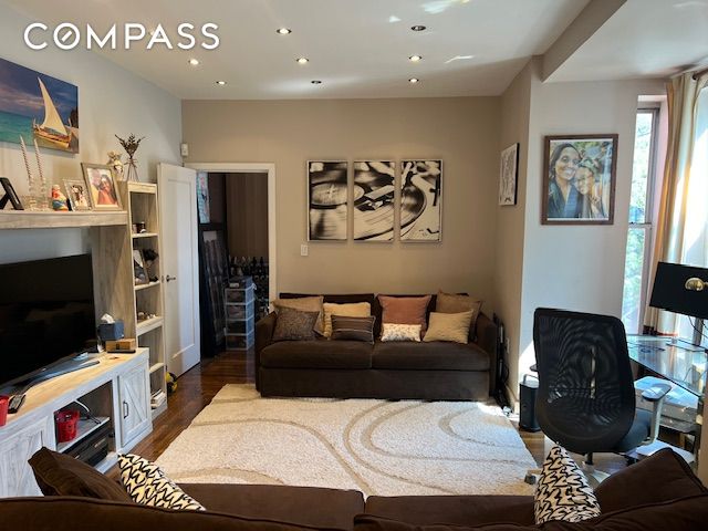 living area with dark wood-type flooring and recessed lighting