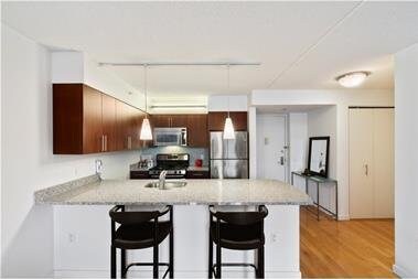 kitchen featuring stainless steel appliances, a breakfast bar, a peninsula, a sink, and light wood-style floors