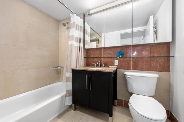 bathroom with toilet, tile patterned flooring, shower / bathtub combination with curtain, vanity, and tile walls