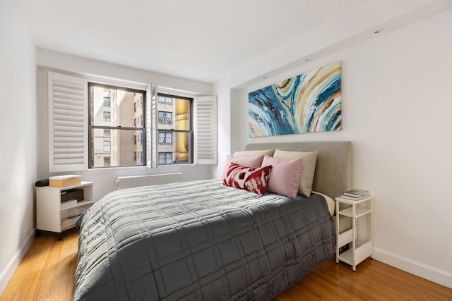 bedroom featuring baseboards and wood finished floors