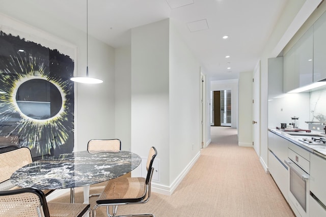 dining room featuring recessed lighting, baseboards, and light carpet