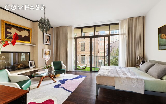 bedroom with expansive windows and wood finished floors