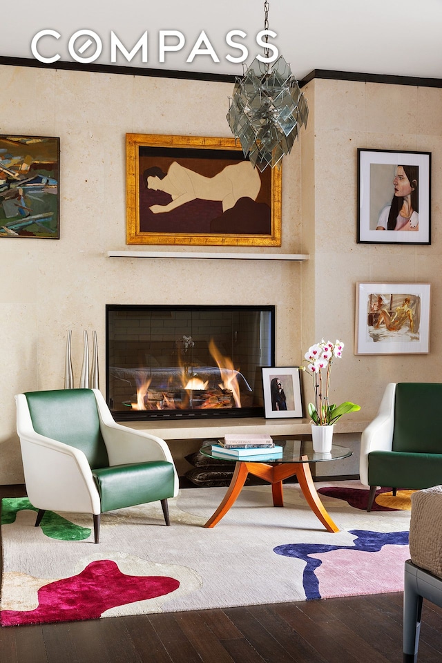 sitting room with wood-type flooring and a glass covered fireplace