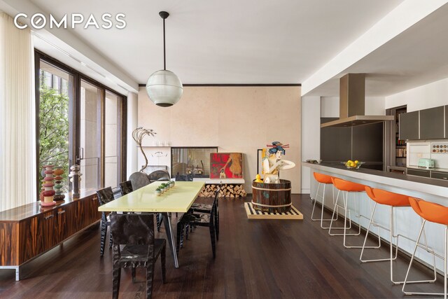 dining room with wood finished floors and a multi sided fireplace