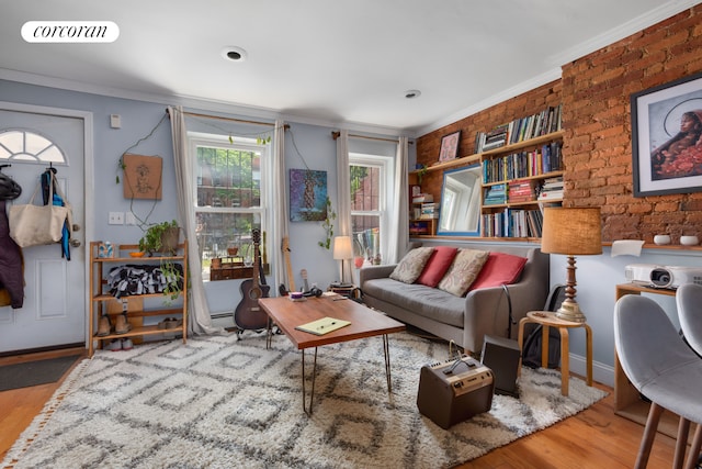 living area with brick wall, visible vents, ornamental molding, and wood finished floors