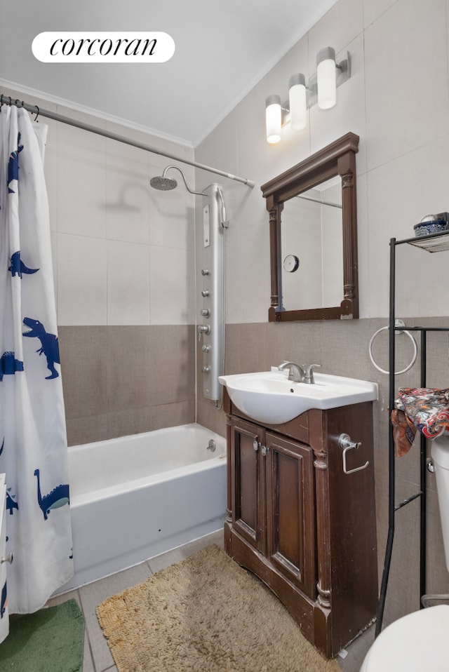 bathroom featuring crown molding, tile walls, shower / bathtub combination with curtain, vanity, and tile patterned flooring