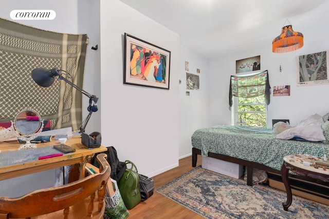 bedroom with wood finished floors and baseboards