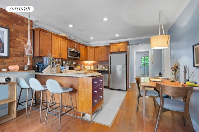 kitchen featuring decorative backsplash, appliances with stainless steel finishes, brown cabinets, a peninsula, and crown molding