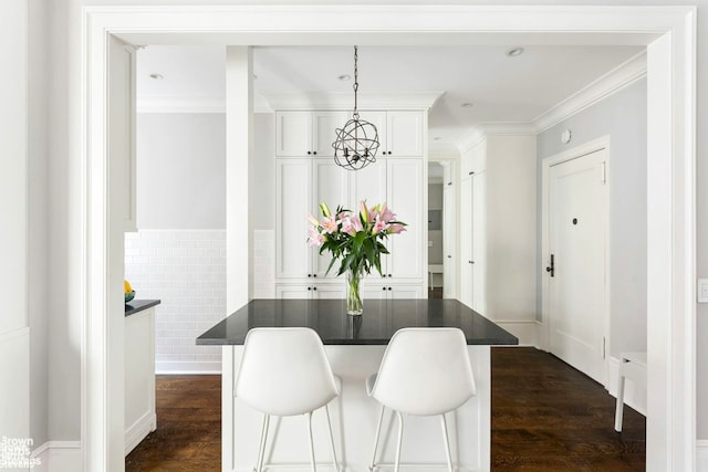 dining room featuring ornamental molding, a chandelier, and dark wood finished floors