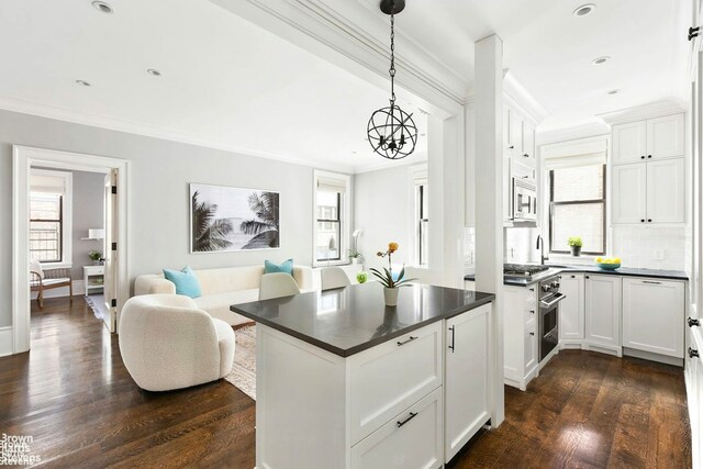 dining area featuring dark wood-style floors, a chandelier, and ornamental molding