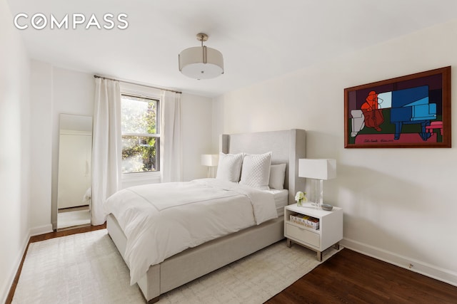 bedroom featuring wood finished floors and baseboards