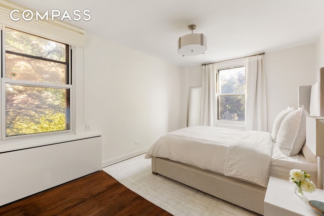 bedroom with baseboards and wood finished floors