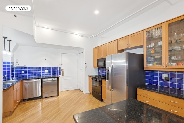 kitchen featuring black appliances, decorative backsplash, light wood-style floors, glass insert cabinets, and dark stone counters