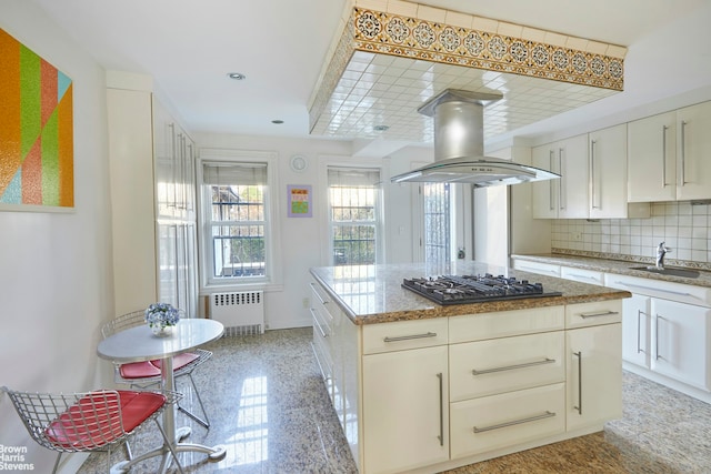 kitchen featuring backsplash, radiator heating unit, a sink, gas cooktop, and island range hood