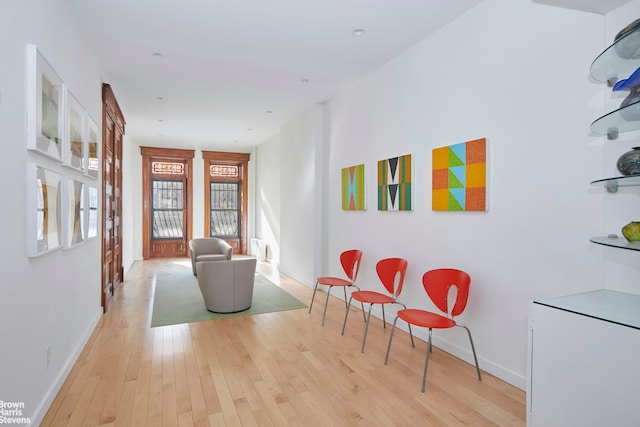 hall featuring baseboards and light wood-style floors