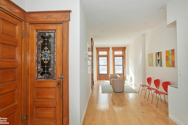 corridor featuring light wood-style floors and baseboards