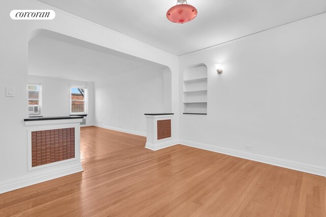 76-15 35th Ave Unit 6O, New York City, NY 11372 - unfurnished living room featuring built in features, visible vents, baseboards, and wood finished floors