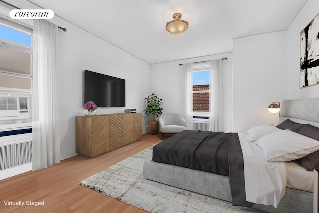 bedroom featuring radiator heating unit and wood finished floors