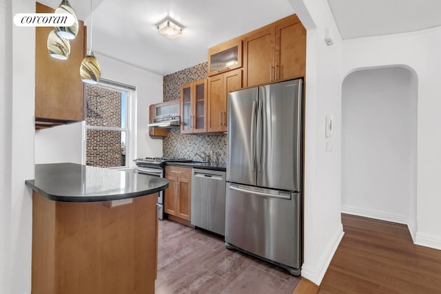 76-15 35th Ave Unit 6O, New York City, NY 11372 - kitchen featuring dark countertops, brown cabinetry, tasteful backsplash, and stainless steel appliances