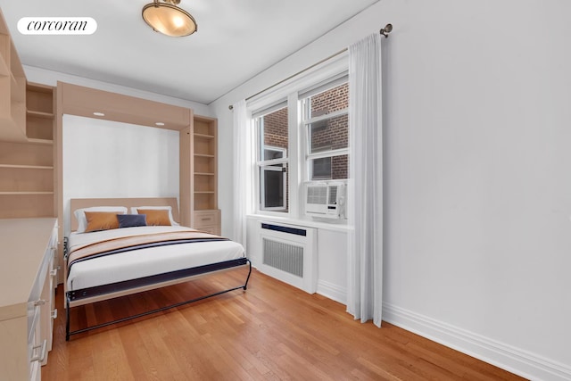 76-15 35th Ave Unit 6O, New York City, NY 11372 - bedroom featuring visible vents, light wood-style flooring, radiator heating unit, cooling unit, and baseboards