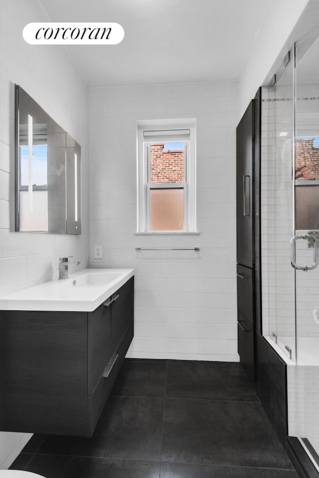 76-15 35th Ave Unit 6O, New York City, NY 11372 - full bathroom with a tub to relax in, a shower with door, tile patterned flooring, vanity, and tile walls