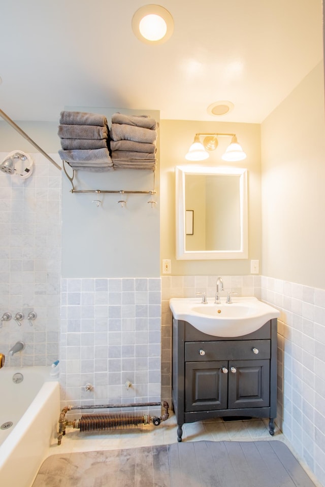 bathroom with a wainscoted wall, shower / tub combination, tile walls, and vanity