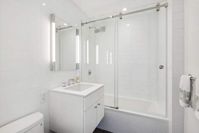 200 E 62nd St Unit 23D, New York City, NY 10065 - full bathroom with toilet, vanity, tiled shower / bath combo, and tile walls