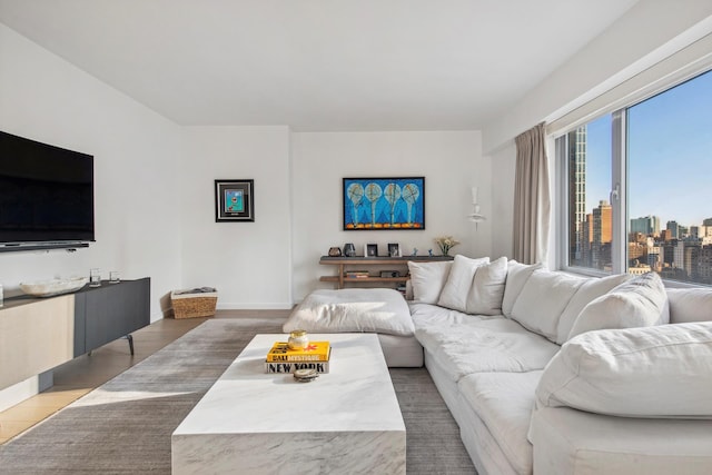 200 E 62nd St Unit 23D, New York City, NY 10065 - living room featuring a view of skyline, wood finished floors, and baseboards