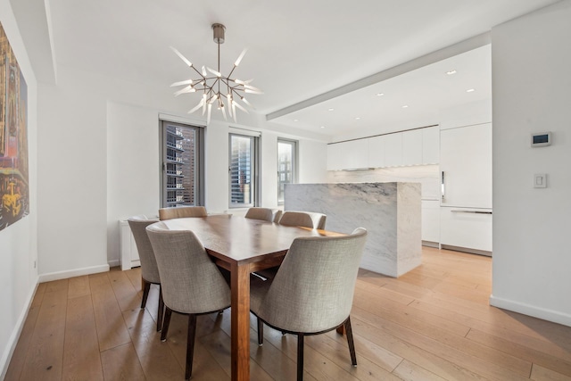 dining room with a chandelier, beam ceiling, baseboards, and light wood finished floors