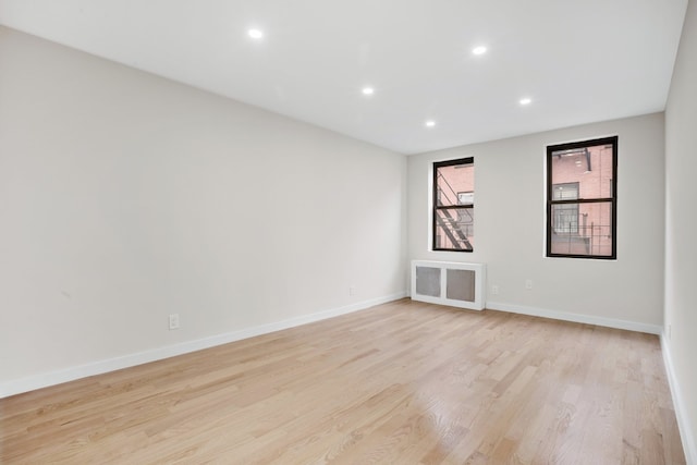 spare room featuring recessed lighting, light wood-style flooring, and baseboards