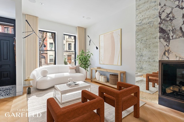 living area featuring a premium fireplace, a wealth of natural light, and wood finished floors