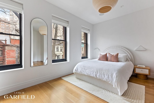 bedroom featuring wood finished floors and baseboards