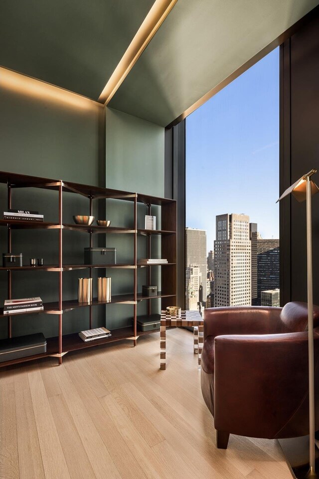 53 W 53rd St Unit 49A, New York City, NY 10019 - living area with wood finished floors, a wall of windows, and a city view