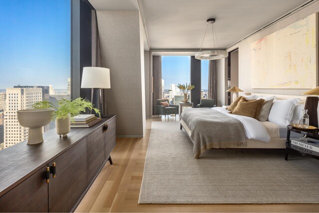 53 W 53rd St Unit 49A, New York City, NY 10019 - bedroom featuring expansive windows, light wood-style flooring, and a view of city