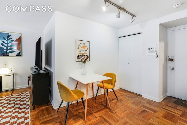 dining room with track lighting and baseboards