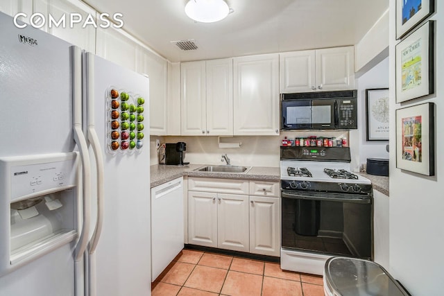 kitchen featuring white appliances, white cabinetry, light countertops, and a sink