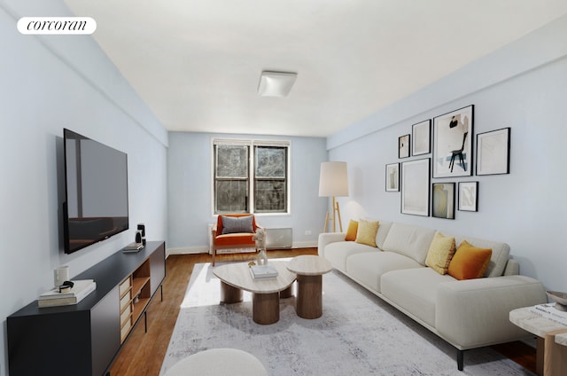 living area with wood finished floors, visible vents, and baseboards