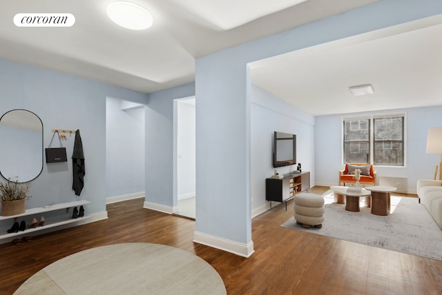 living room featuring wood finished floors, visible vents, and baseboards