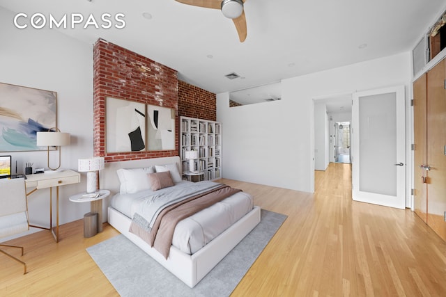 bedroom with visible vents, ceiling fan, and wood finished floors