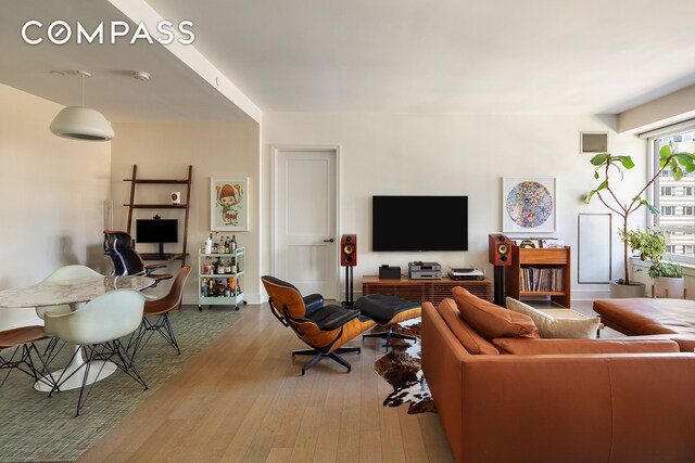 living area with visible vents and wood finished floors