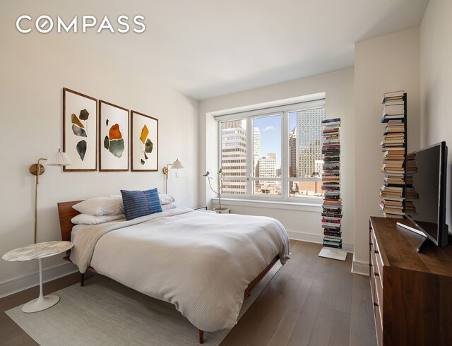 bedroom with dark wood finished floors and baseboards