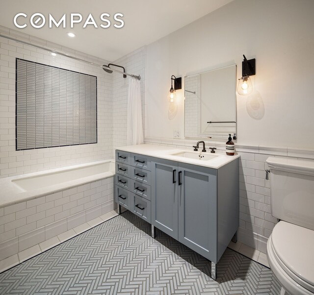 bathroom featuring tiled shower / bath, vanity, tile patterned flooring, and toilet