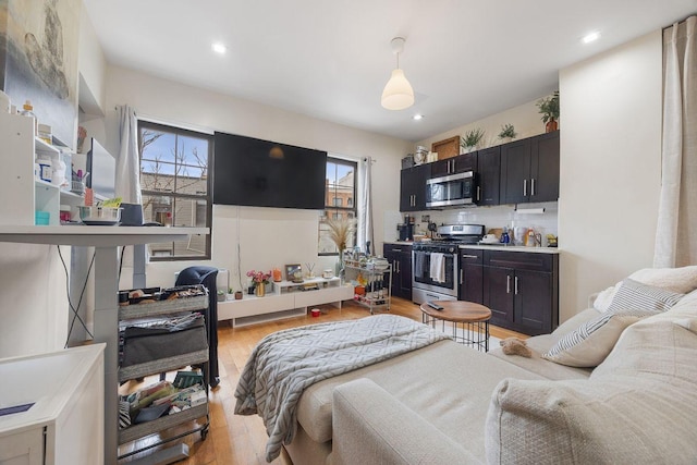 bedroom with recessed lighting, light wood-type flooring, and multiple windows