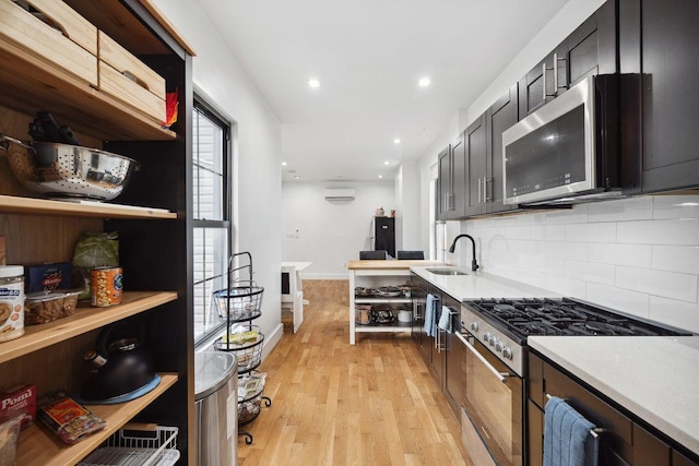 118 Kingsland Ave Unit 1, New York City, NY 11222 - kitchen with stainless steel appliances, a sink, light countertops, an AC wall unit, and tasteful backsplash