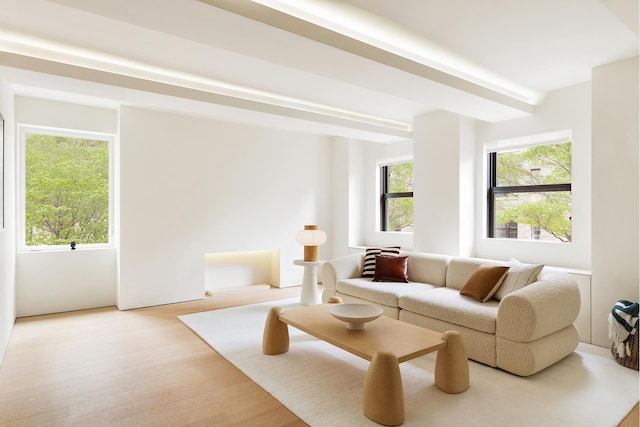 living area with beam ceiling and light wood-style floors