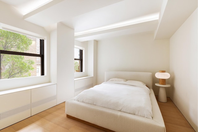 bedroom with light wood finished floors and radiator heating unit