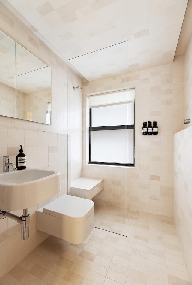 bathroom featuring toilet, tile walls, tiled shower, and tile patterned flooring